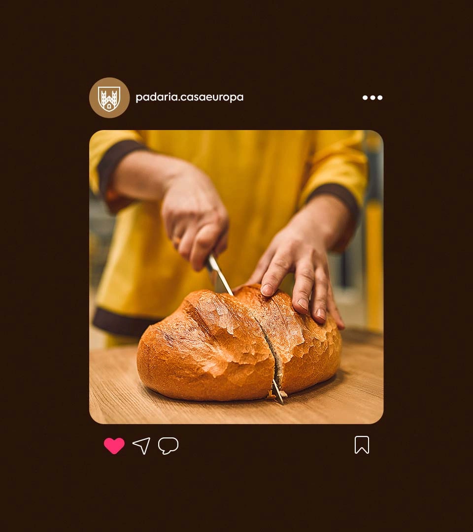 Post da Casa Europa no Instagram: uma atendente de uniforme amarelo cortando um pão sobre a tábua, no perfil @padaria.casaeuropa.