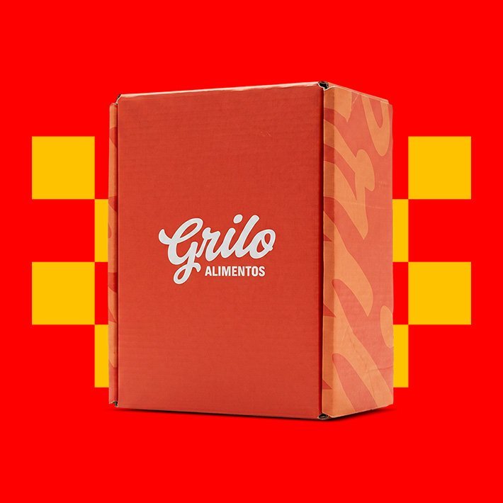 Caixa de papelão da Grilo Alimentos sobre o padrão xadrez amarelo e vermelho da marca