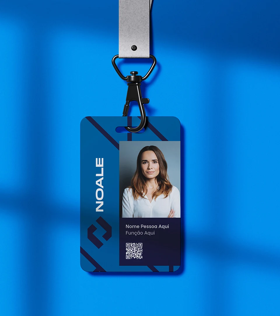 Crachá da Noale pendurado num cordão, com a marca no topo, a foto de uma colaboradora, o nome e um QR code, sobre fundo azul.